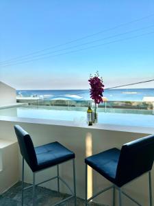 a bar with two chairs and a bottle of wine at Haven Beach in Faliraki