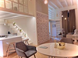 a living room with a table and chairs and stairs at Loft prestigioso nel centro di Sanremo in Sanremo