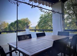 einen Holztisch und Stühle auf einer Veranda in der Unterkunft Villa avec piscine au calme in Seillans