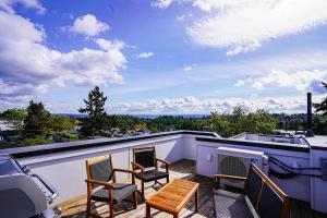 d'un balcon avec des chaises et une cheminée sur le toit. dans l'établissement New contemporary home, roof top deck, king bed, à Seattle