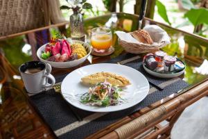a table with a plate of food and a bowl of food at The Botanic Garden Hotel in Siem Reap