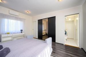 1 dormitorio blanco con 1 cama grande y baño en Family retreat with a sauna in the centre en Kuressaare