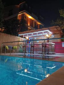 a swimming pool at night with chairs and a building at Beyaz Melek Hotel in Antalya