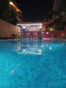 una piscina por la noche con una mesa. en Beyaz Melek Hotel, en Antalya