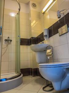 een badkamer met een toilet, een wastafel en een douche bij Hotel Adria in Ruda Śląska