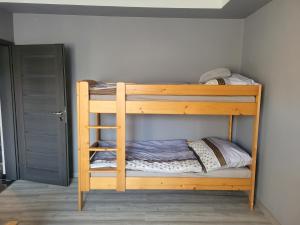 drewnianym łóżkiem piętrowym w pokoju w obiekcie Rodinný dom Podhájska w mieście Podhájska