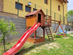 a playground with a slide and a play house at Rodinný dom Podhájska in Podhájska