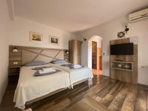 a bedroom with a large bed and a flat screen tv at Guesthouse HHL - Liman ll in Ulcinj