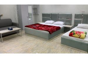 穆桑納的住宿－Super OYO 150 Reef Al Khaleej Resort，一间带两张床和一张沙发的卧室