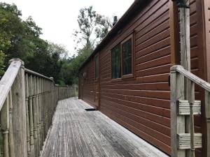 a wooden walkway next to a wooden building at Snowdonia Holiday Lodges in Beddgelert