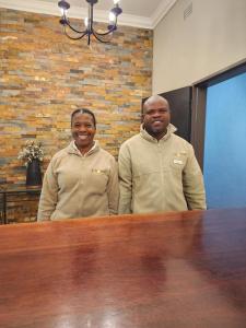 two men standing next to a wooden table at Karongwe Portfolio- Shiduli Private Game Lodge in Karongwe Game Reserve