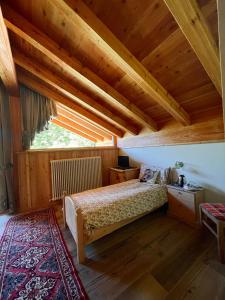 een slaapkamer met een bed en een houten plafond bij B&B Maso al Cervo in Fiera di Primiero