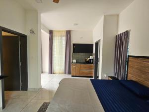 a bedroom with a large bed and a kitchen at Sambhrama Grand in Mysore