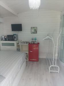 a bedroom with a bed and a red cabinet and a desk at Casetta vista mare con piscina in Corsanico-Bargecchia