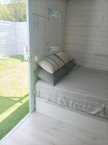 a small bed in a small room with a window at Casetta vista mare con piscina in Corsanico-Bargecchia