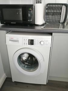 a microwave sitting on top of a washing machine at *Zzzz Suite*Relaxing City Centre Apartment* in Liverpool