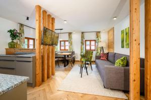 a living room with a couch and a table at Thorbäck Gut - Apartments im Schlosserhaus in Öblarn