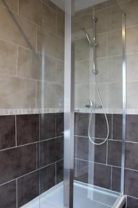 La salle de bains est pourvue d'une douche avec une porte en verre. dans l'établissement Le Clos Castel, à Raids
