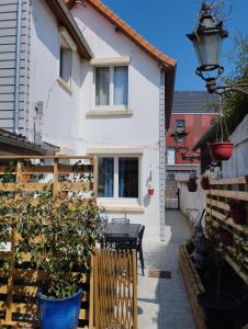 Uma casa branca com um banco à frente. em Charmante dépendance 10 mn à pieds plage, commerces em Berck