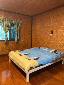 um quarto com uma cama grande e lençóis azuis em แพจิตรธาดาธารน้ำ em Tha Kradan