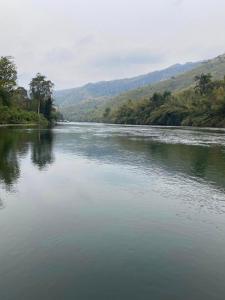 a view of a river with mountains in the background at แพจิตรธาดาธารน้ำ in Tha Kradan