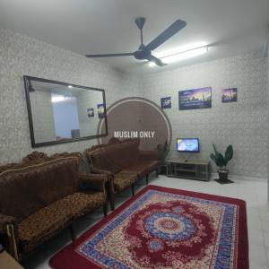 una sala d'attesa con divani, specchio e tappeto di THIFFAH HOMESTAY KUALA PERLIS a Kuala Perlis