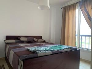 1 dormitorio con 1 cama grande y ventana grande en Lovely sea & pool view Rental unit, " 3 bedrooms For Families Only", en Ain Sokhna