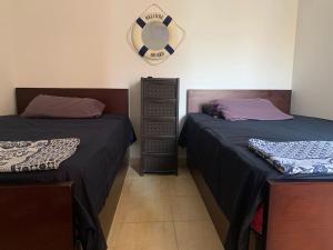 una camera con due letti e un orologio a muro di Lovely sea & pool view Rental unit, " 3 bedrooms For Families Only" a Ain Sokhna