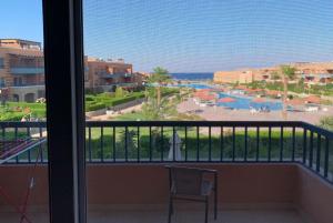 a balcony with a view of a pool and the ocean at Lovely sea & pool view Rental unit, " 3 bedrooms For Families Only" in Ain Sokhna