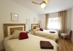 a hotel room with two beds and a window at La Casita de Rosa - Sierra de Francia in Aldeanueva de la Sierra