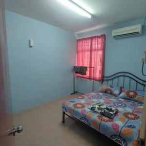 THIFFAH HOMESTAY KUALA PERLIS في كوالا برليس: غرفة نوم بسرير ونافذة حمراء
