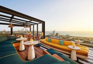 a room with couches and tables and a view of the ocean at Four Seasons Hotel Mumbai in Mumbai