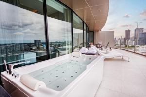 a bathroom with a tub with a view of the city at Valia Hotel Bangkok in Bangkok