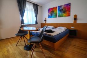 1 dormitorio con 1 cama, mesa y sillas en Flataid Gästehaus Graschi - Steinbergstraße, en Graz