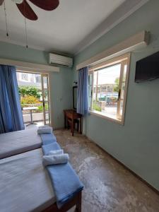 a bedroom with three beds and a window at Ammogion in Tolo