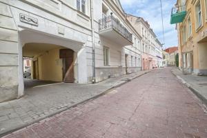 an empty street in a city with white buildings at Cosy 3 room apartment. in Vilnius