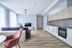 a kitchen and living room with a table and chairs at Cosy 3 room apartment. in Vilnius