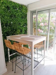 a white table and chairs on a patio at Appartement Zen à Frejus avec jardin, piscine, tennis, proche mer in Fréjus