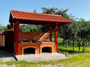 a pavilion with an outdoor kitchen in a yard at Casa de vacanță Orsi in Sovata