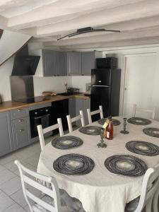 a kitchen with a table with chairs and a kitchen with a tableablish at Logement de charme à Azay le Rideau in Cheillé