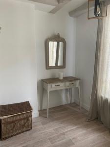 a dressing table in a room with a mirror at Logement de charme à Azay le Rideau in Cheillé