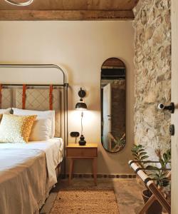 a bedroom with a bed with a mirror and a table at Pyrgi Cretan Living & Spa in Pírgos