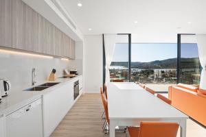 a kitchen with a table and chairs and a large window at Lake View Suites Jindabyne in Jindabyne
