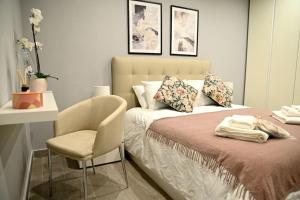 - une chambre avec un lit et une chaise dans l'établissement 2 Bedroom Luxury Apartment in Madliena Swieqi, à Is-Swieqi