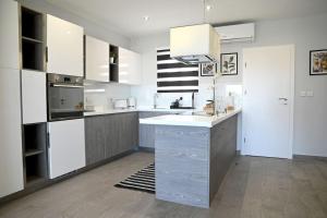 une cuisine avec des placards blancs et un comptoir dans l'établissement 2 Bedroom Luxury Apartment in Madliena Swieqi, à Is-Swieqi