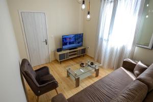a living room with a couch and a tv at Villa Saitan Bazaar in Preveza
