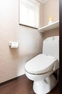 uma casa de banho com um WC branco e uma janela em 楓ホテル402 em Osaka