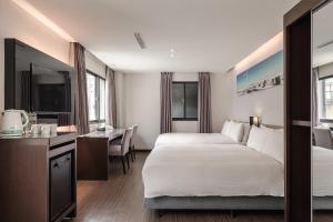 um quarto de hotel com duas camas e uma secretária em Hotel Yoshi em Kaohsiung