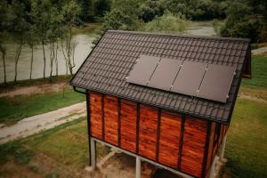 Etno Kutak Purtić في Ljubovija: مبنى صغير عليه لوحات شمسية