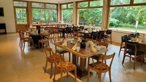 uma sala de jantar com mesas, cadeiras e janelas em Hotel Lethehof em Wardenburg